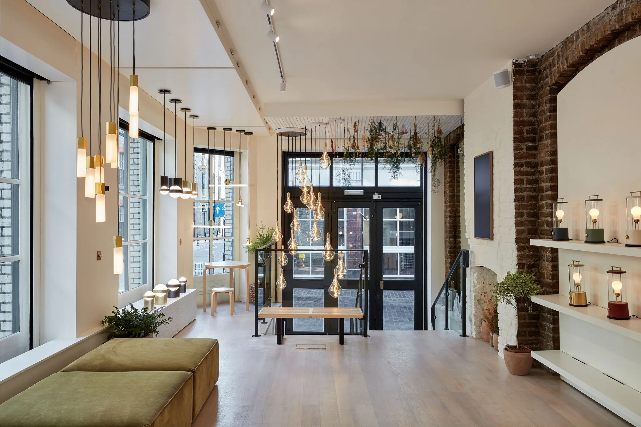 Tala showroom with clusters of pendant bulbs, oak floor and a glazed entrance