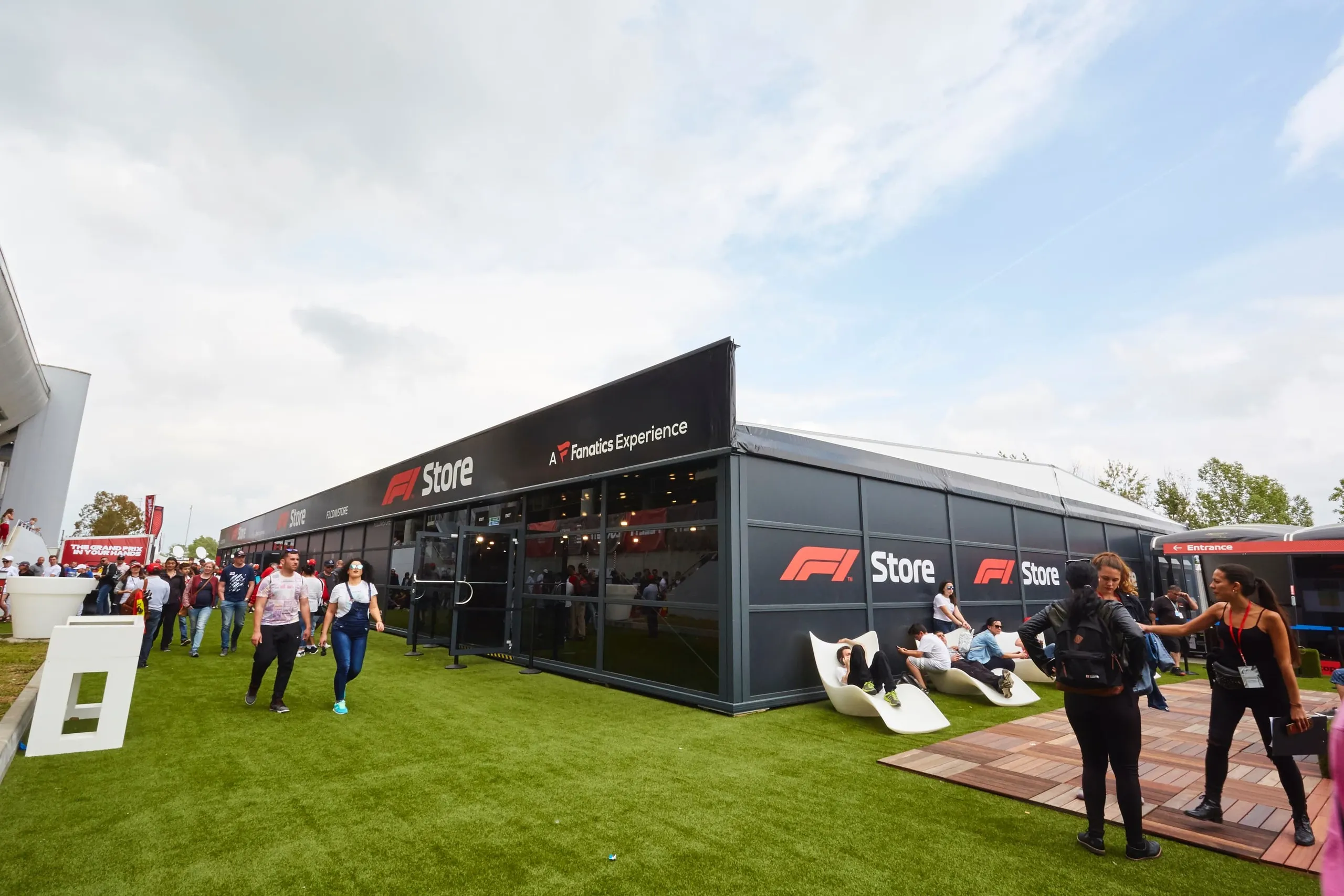 Formula 1 pop-up store marquee with fans on artificial grass outside