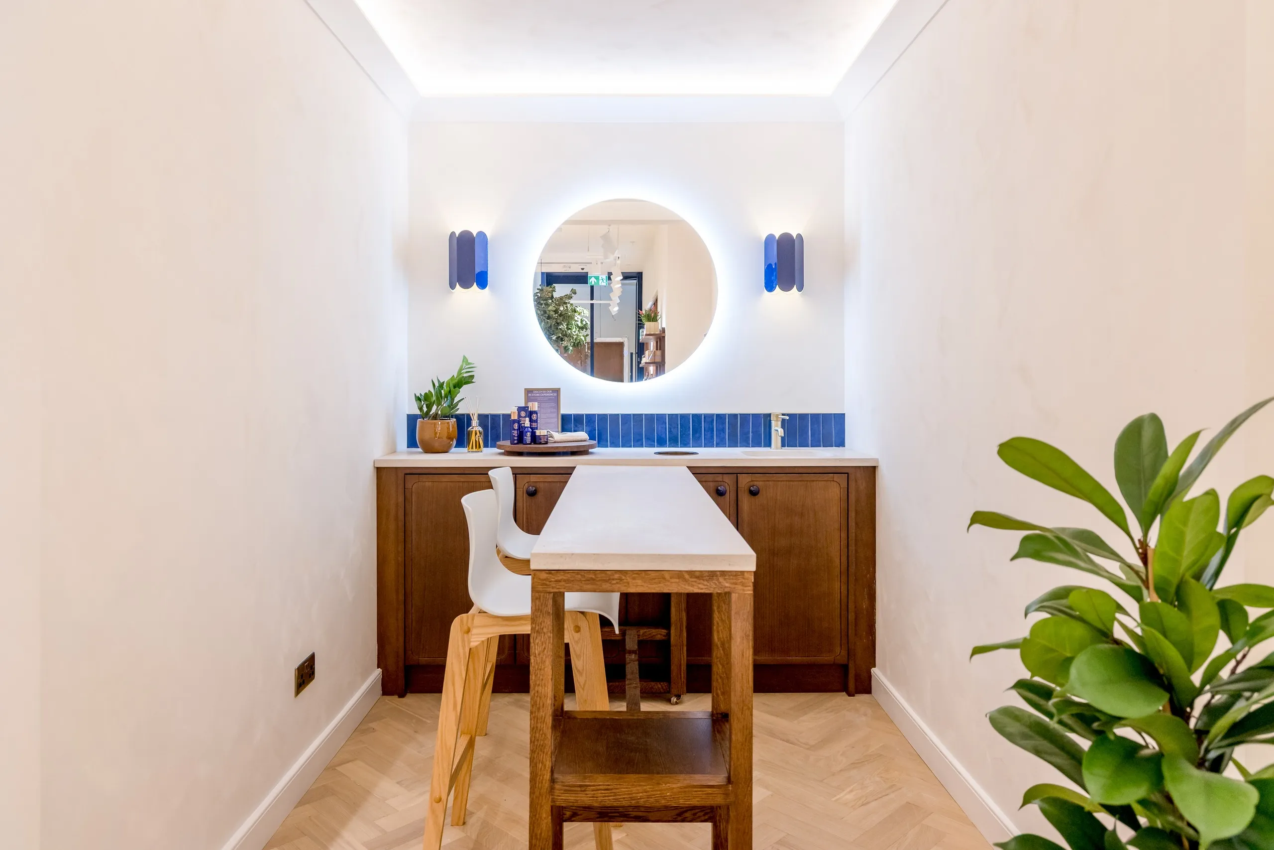 Neal's Yard Remedies store with timber shelving, a central tree display and herringbone floor
