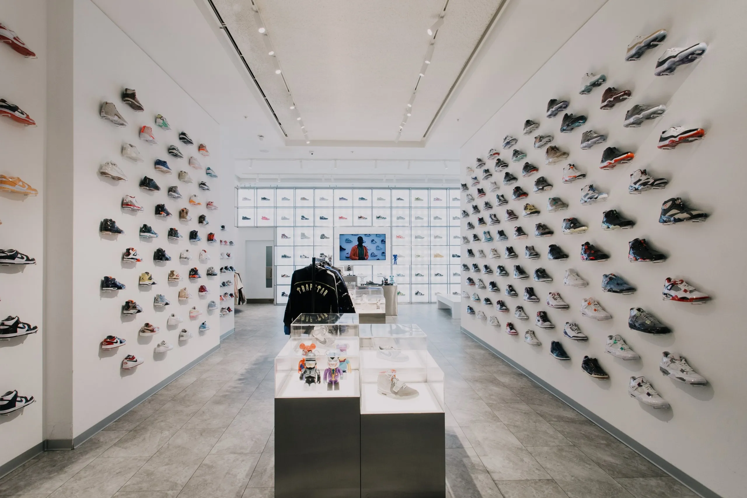 Kick Game store with walls of floating trainer shelves and a glass display case