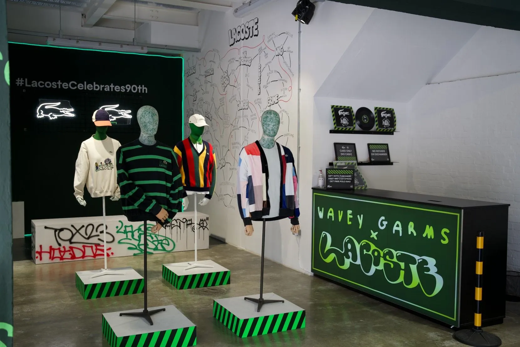 Lacoste x Wavey Garms pop-up with mannequins on striped plinths and graffiti walls