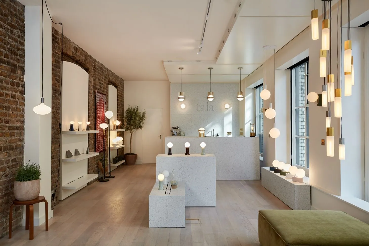 Tala lighting showroom with exposed brick, pendant lights and white display plinths
