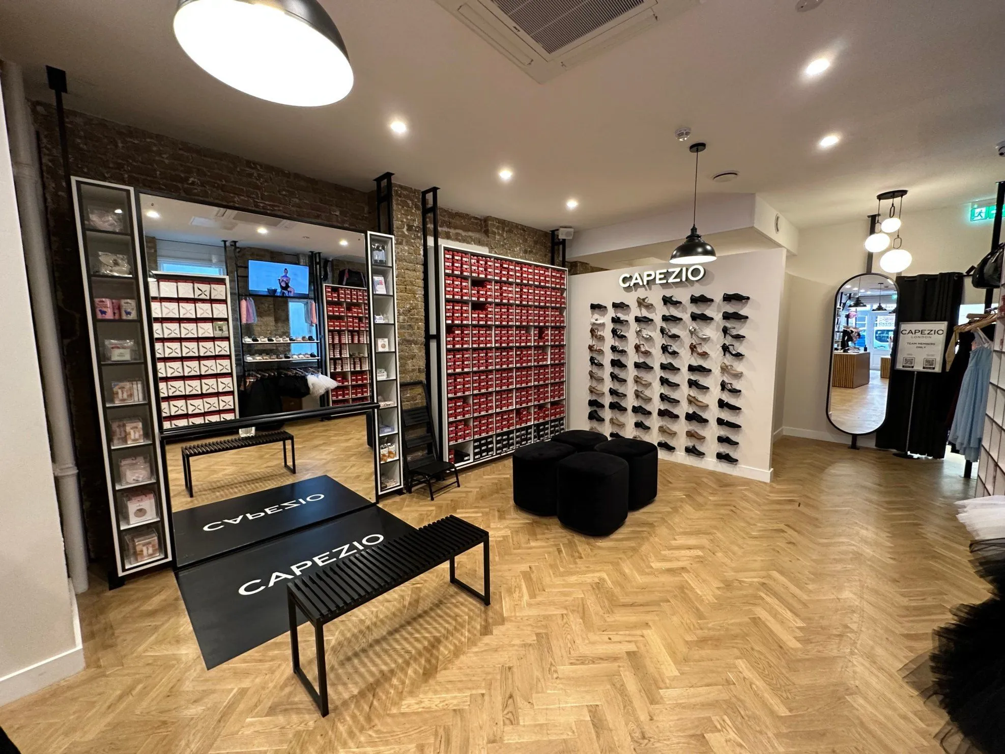 Capezio store with walls of shoe boxes, herringbone floor and branded entrance mats
