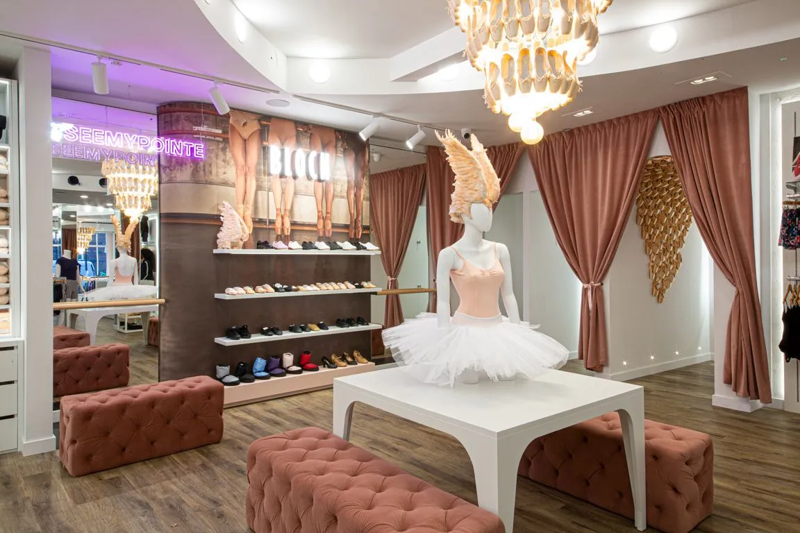 Bloch store with a tutu mannequin, pink velvet seating and a feather chandelier