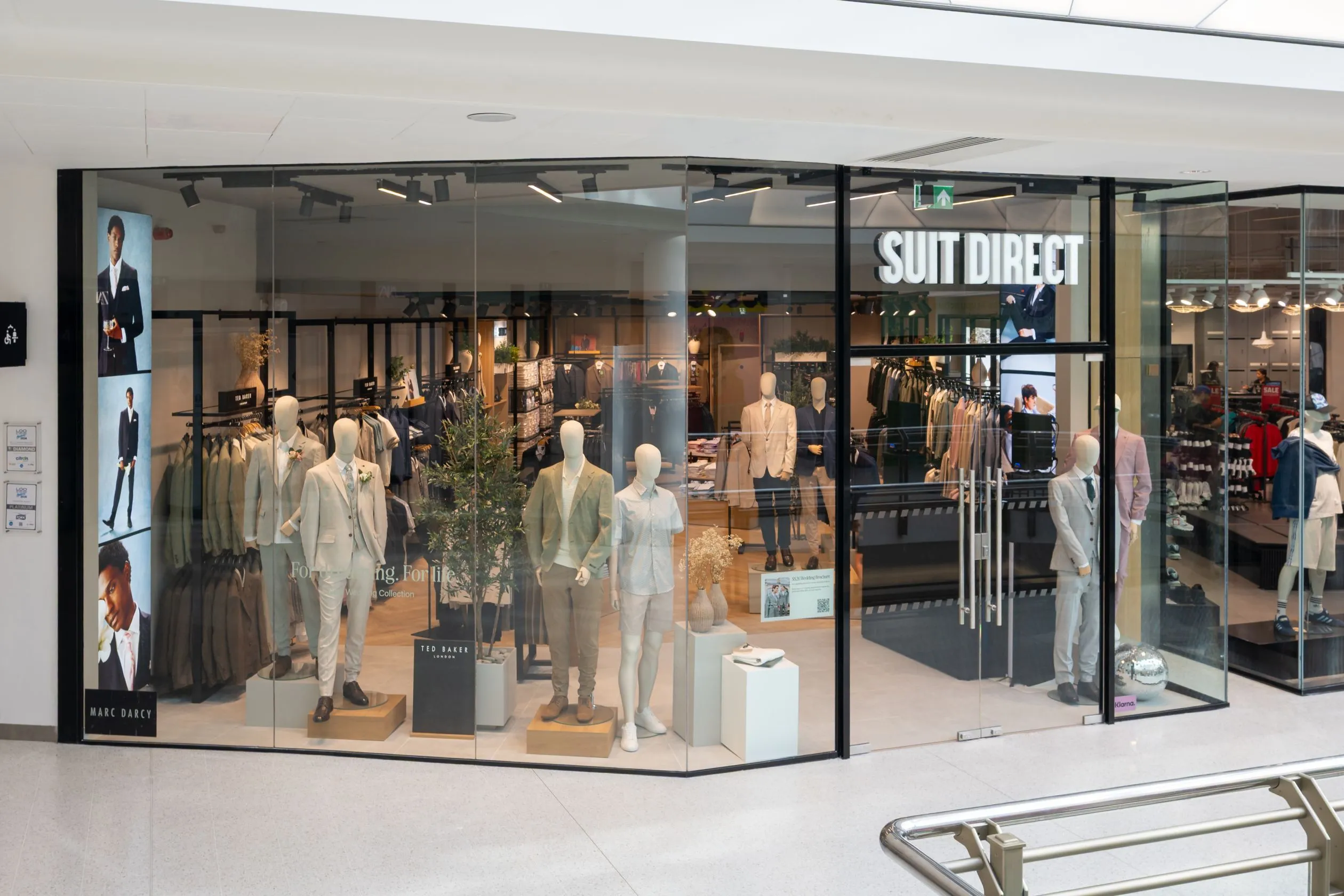 Suit Direct shopfront with suited mannequins behind full-height glazing