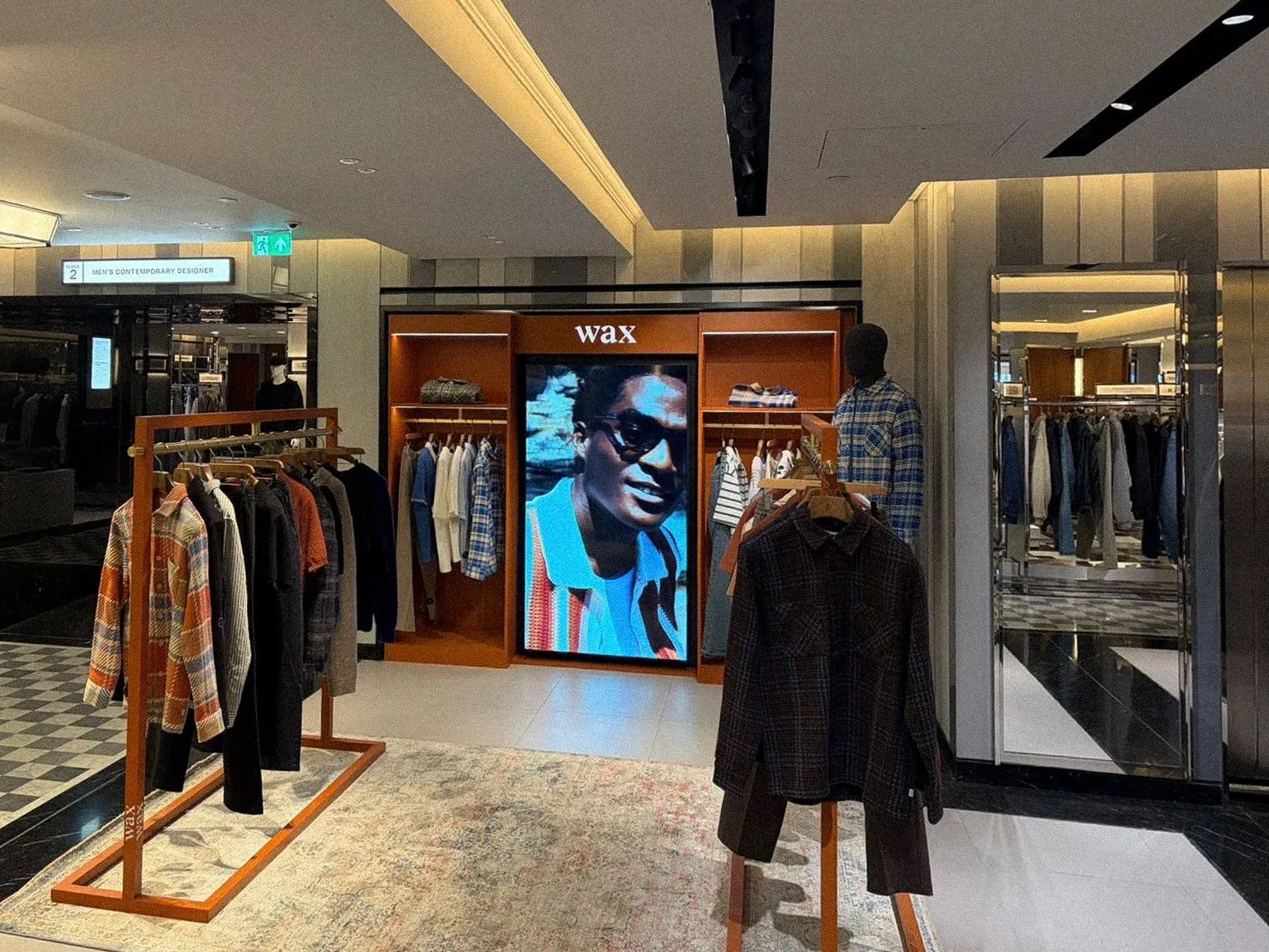 Wax London concession with timber rails and a digital screen