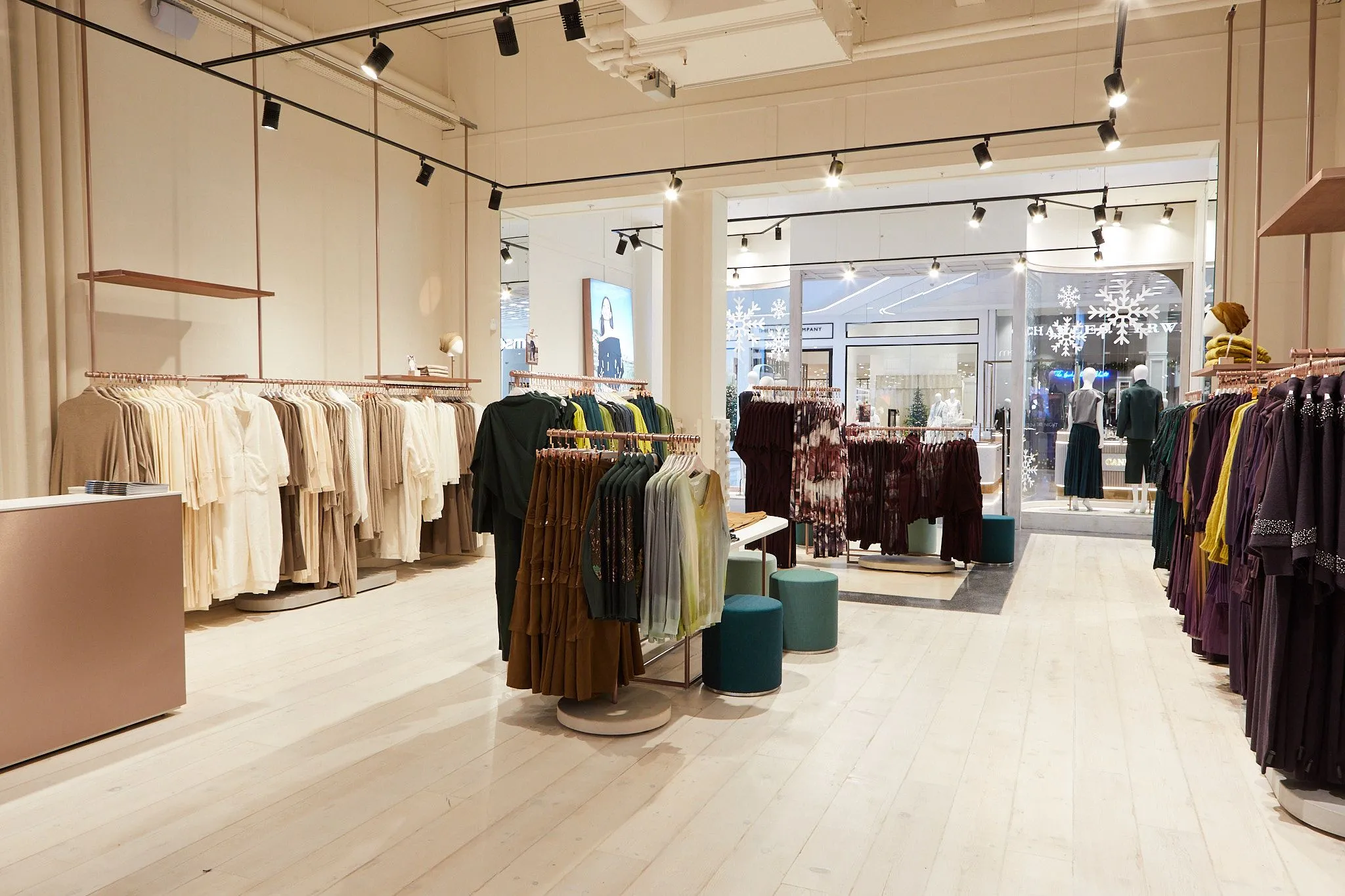 Fashion boutique with rose-gold rails, track lighting and pale timber floor