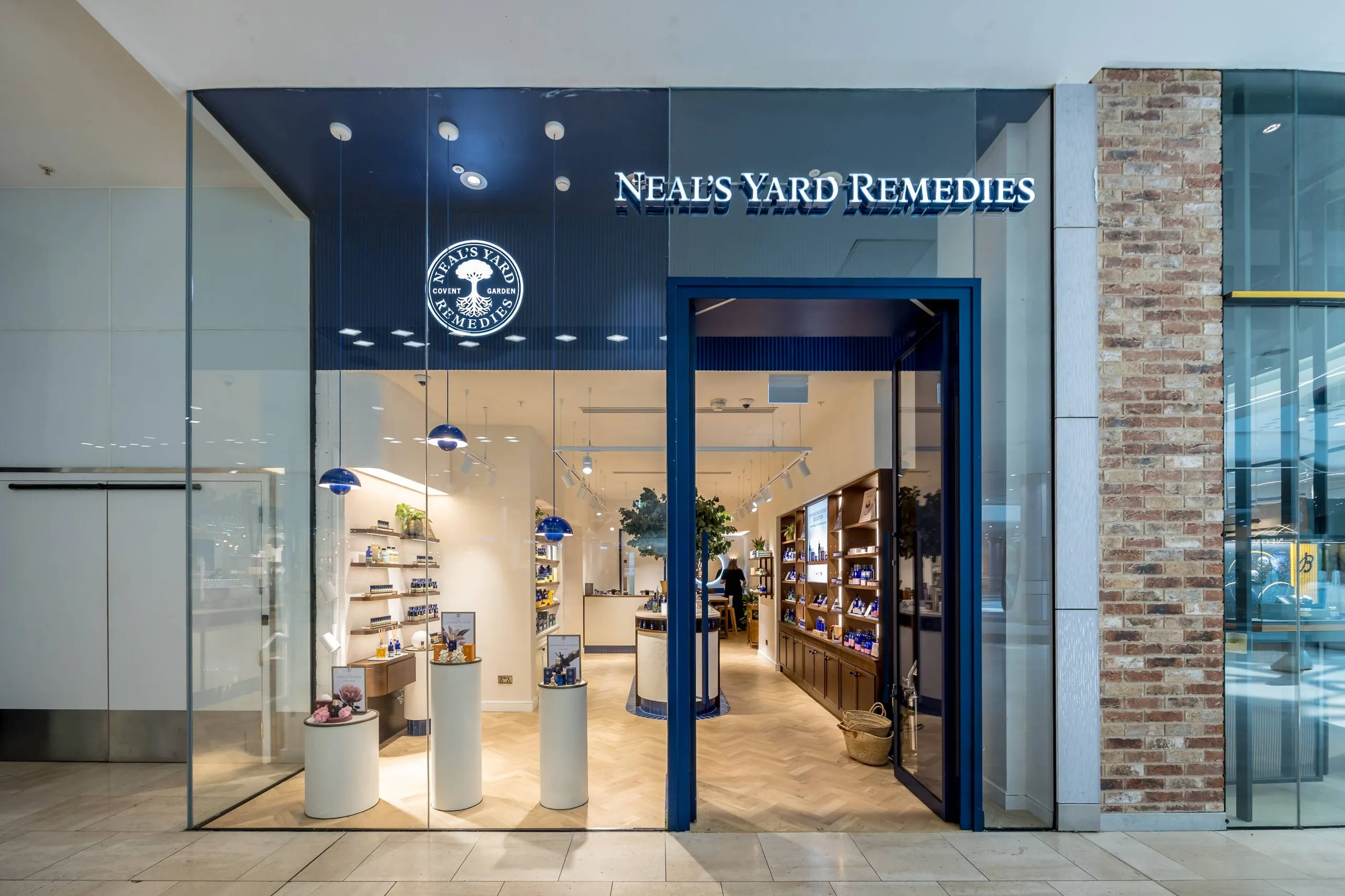 Neal's Yard Remedies shopfront with navy fascia and glazed frontage in a shopping centre