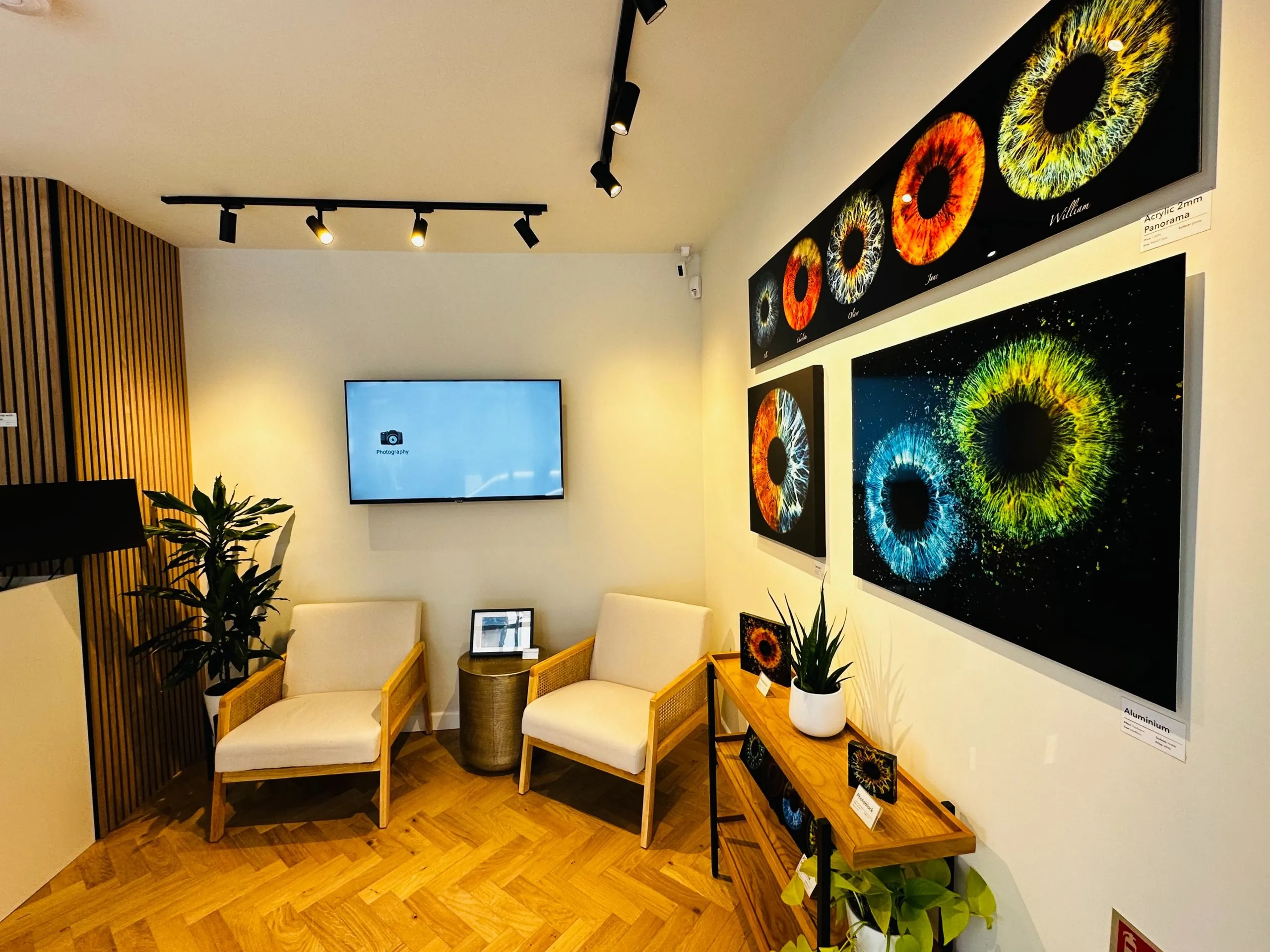 Consultation room with armchairs, oak flooring and large iris artworks