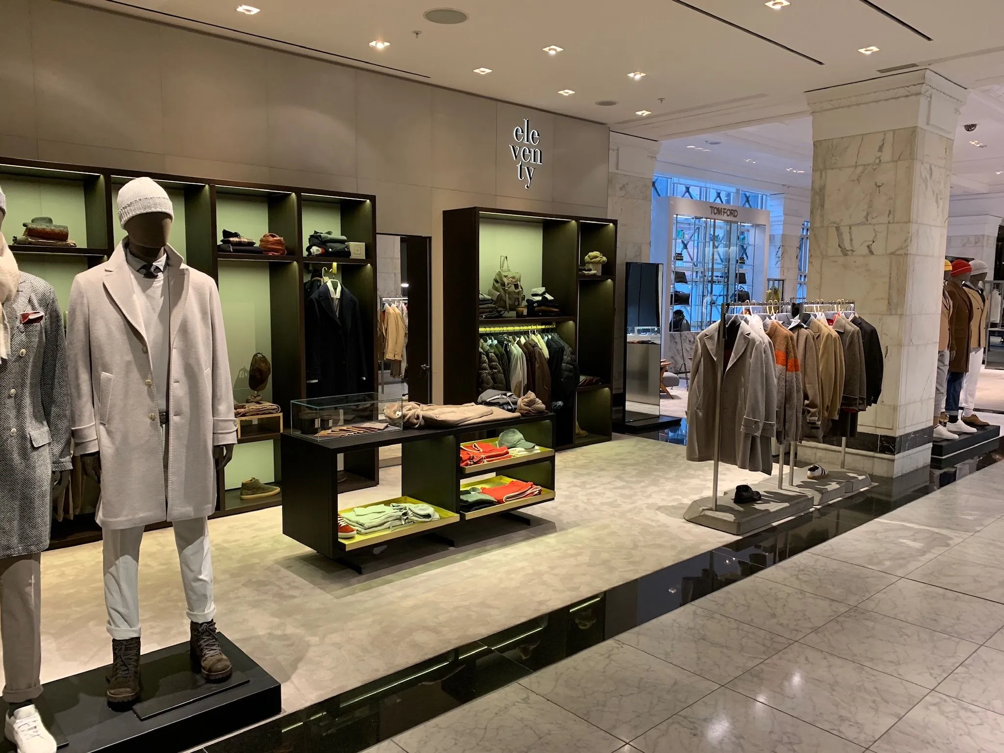 Eleventy concession with black shelving, mannequins and menswear on rails