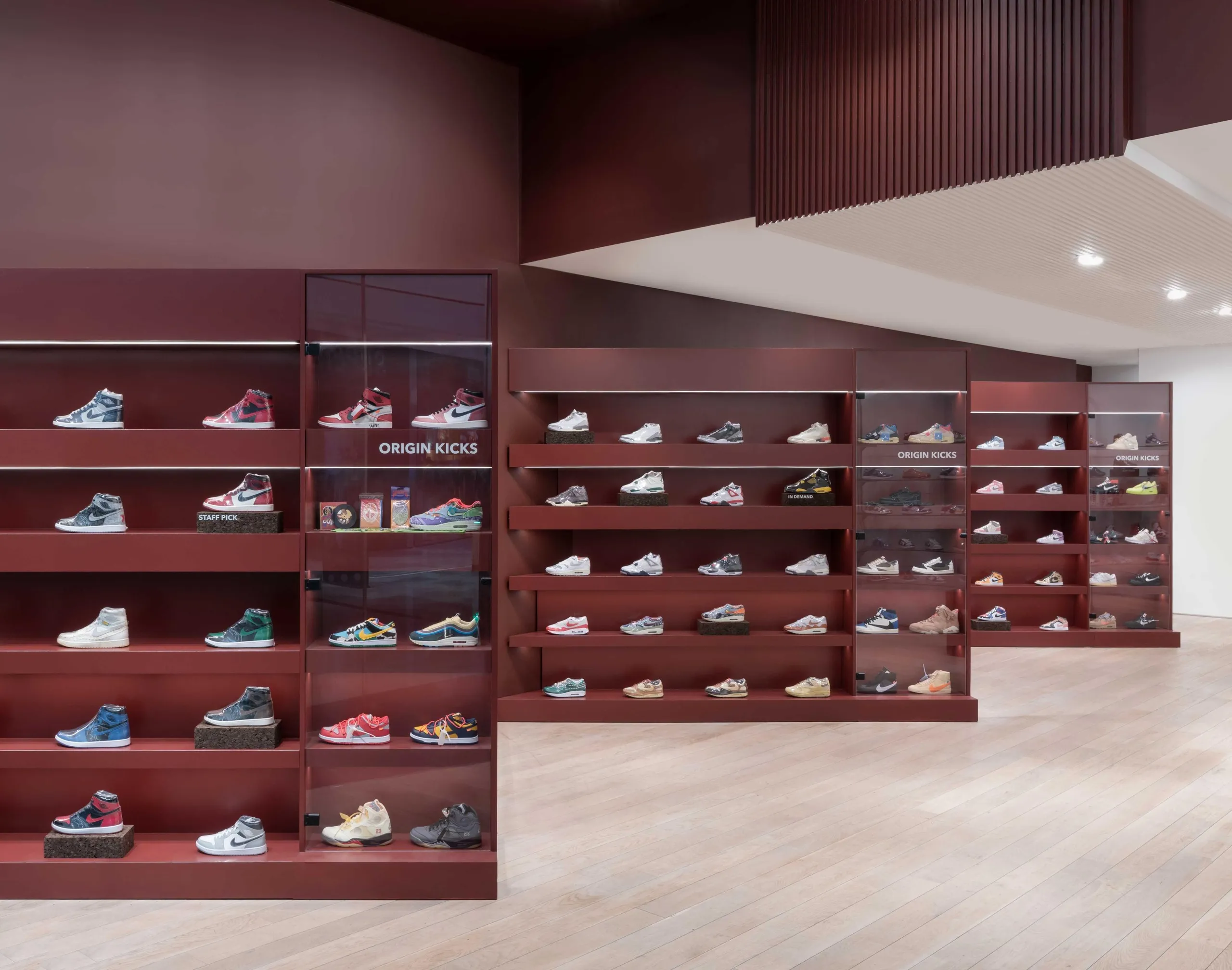 Origin Kicks burgundy display walls of trainers on a pale timber floor