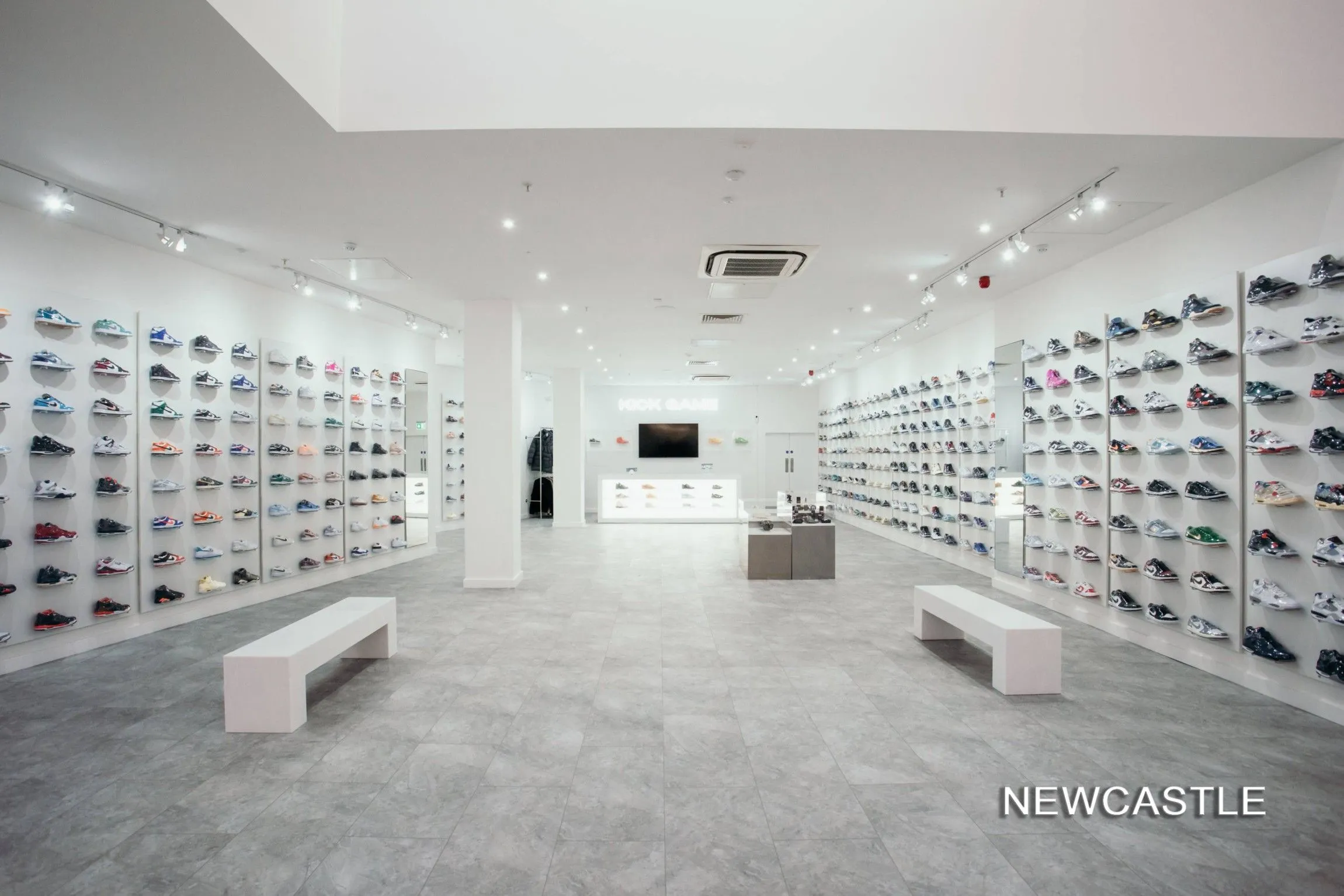 Kick Game Newcastle store with long walls of trainers and white benches