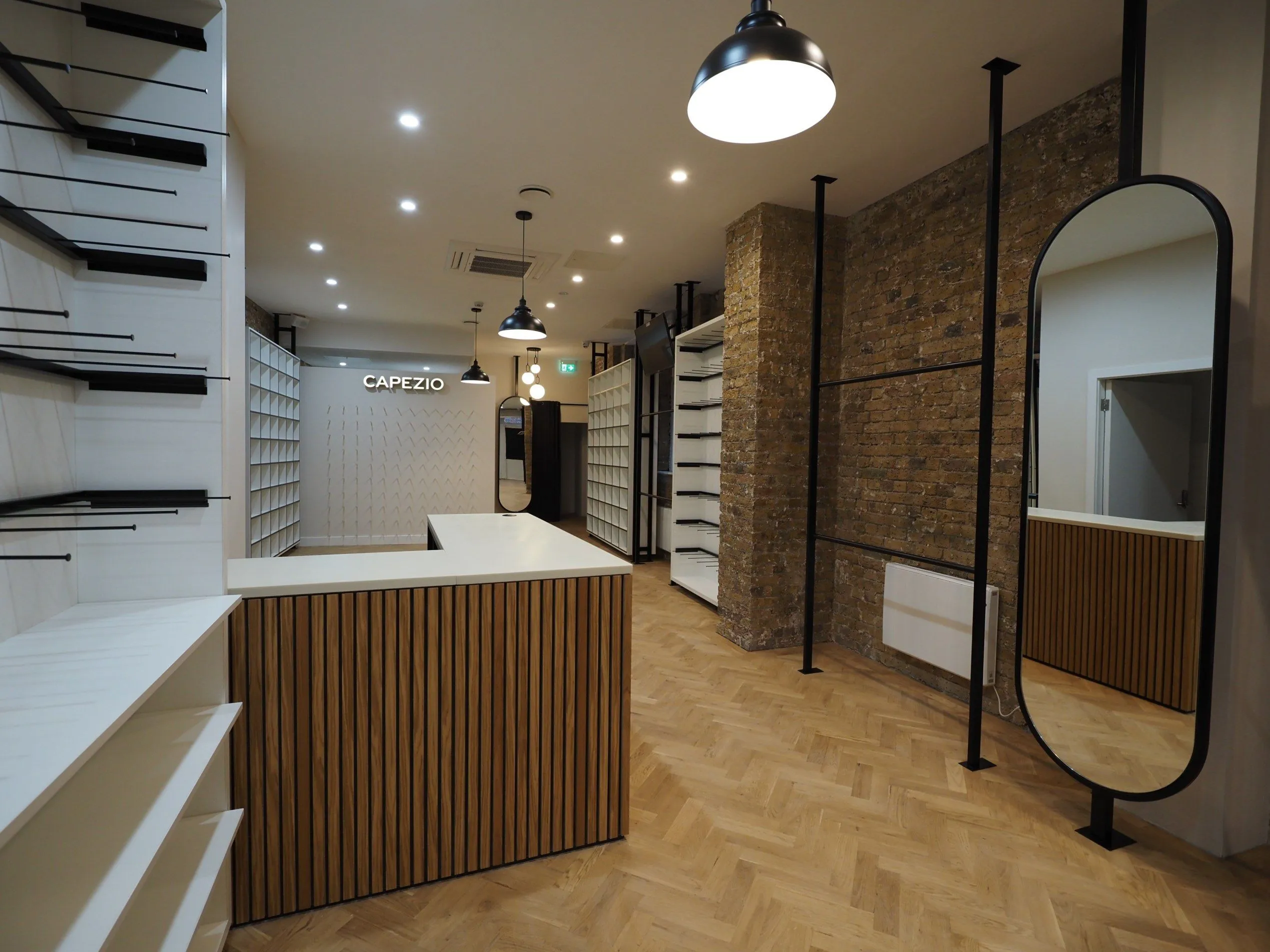 Capezio store with oak counter, brick wall, herringbone floor and black steel fittings