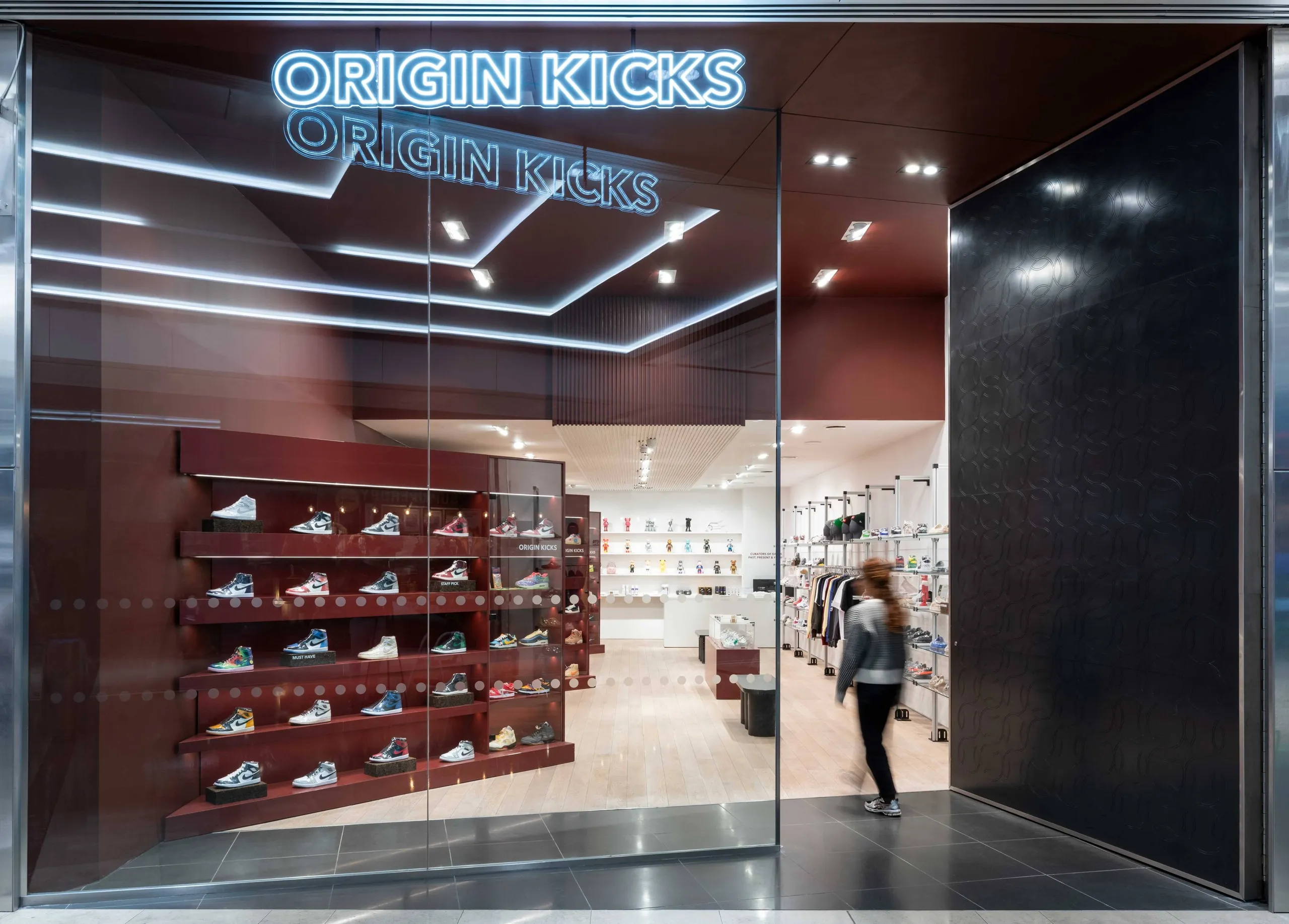 Origin Kicks store front with neon sign and a burgundy trainer wall
